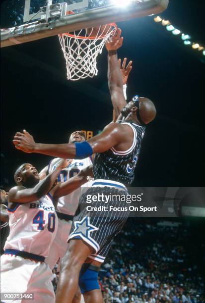 Horace Grant of the Orlando Magic tips the ball in over Calbert Cheaney of the Washington Bullets during an NBA basketball game circa 1994 at the US...