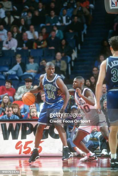 Isiah Rider of the Minnesota Timberwolves backs in on Calbert Cheaney of the Washington Bullets during an NBA basketball game circa 1994 at the US...