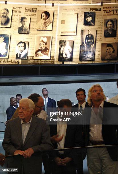 Former US president Jimmy Carter and British business tycoon Sir Richard Branson look at pictures of Holocaust victims in the Hall of Names at the...