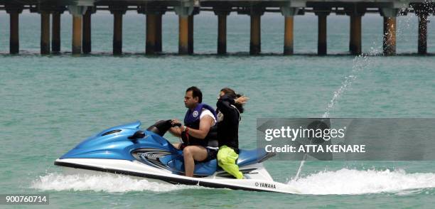 An Iranian couple jet-ski off Kish island, 14 August 2006. Iran prides itself on the natural beauties of this Gulf island, where the Islamic republic...