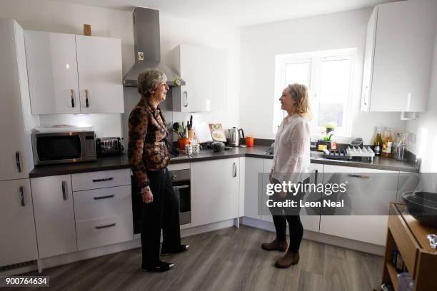 British Prime Minister Theresa May chats with first-time buyer Laura Paine during a visit to new housing development Montague Park on January 3, 2018...