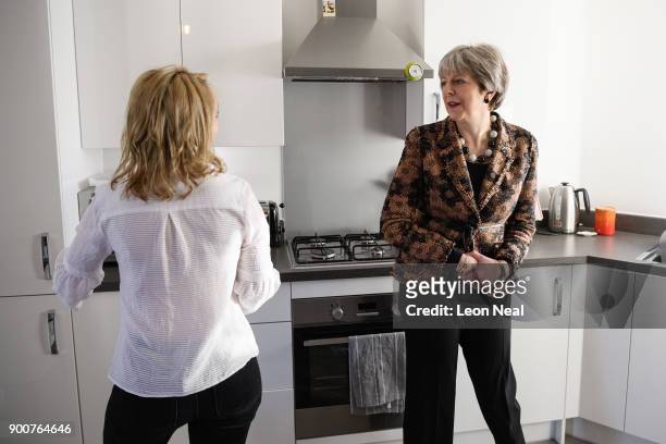 British Prime Minister Theresa May chats with first-time buyer Laura Paine during a visit to a new housing development on January 3, 2018 in...