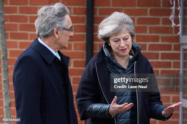 British Prime Minister Theresa May talks with Conservative MP for Wokingham John Redwood during a visit to a new housing development on January 3,...