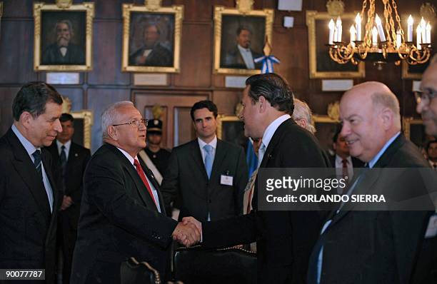 Honduran interim leader Roberto Micheletti shakes hands with Panamanian Minister of Foreign Affairs Juan Carlos Varela during a meeting with the head...