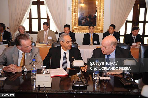 The head of the Organization of American States , Jose Miguel Insulza , speaks with Canadian Minister of Foreign Affairs Peter Kent and a...