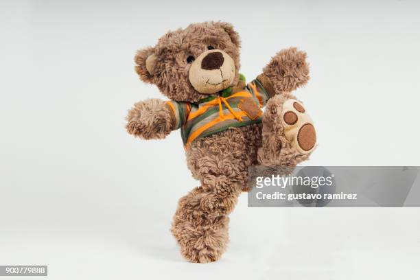brown stuffed bear kicking - bear on white stock-fotos und bilder