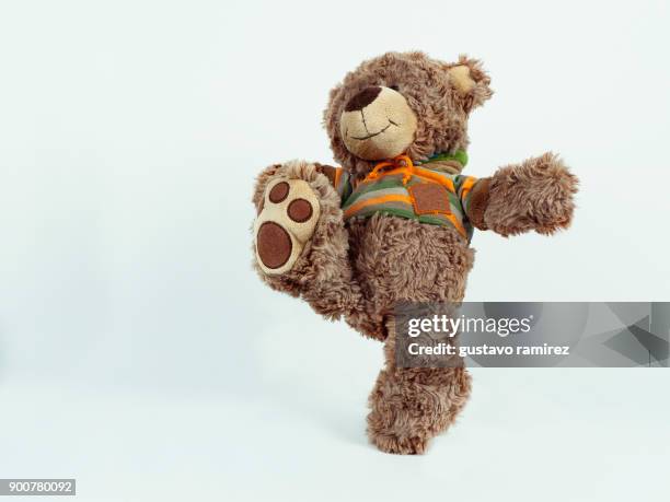 brown stuffed bear kicking - teddybär freisteller stock-fotos und bilder