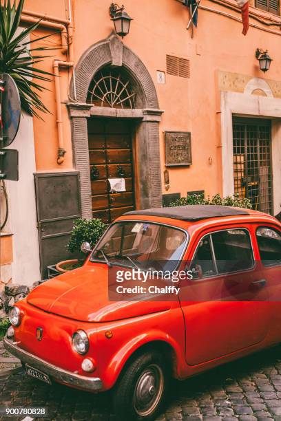 vintage italiaanse rode auto op geplaveide straat - fiat 500 stockfoto's en -beelden