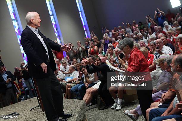 People cheer as U.S. Sen. John McCain listens to a question from a woman in the crowd as he speaks about health care reform during a town hall...