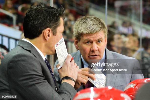 Carolina Hurricanes head coach Bill Peters talks with assistant coach Rod Brind'Amour on the bench during a game between the Carolina Hurricanes and...
