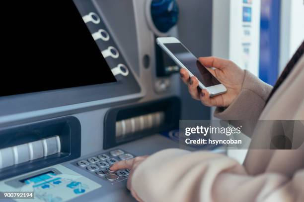 cash dispenser with smartphone - bank stock pictures, royalty-free photos & images