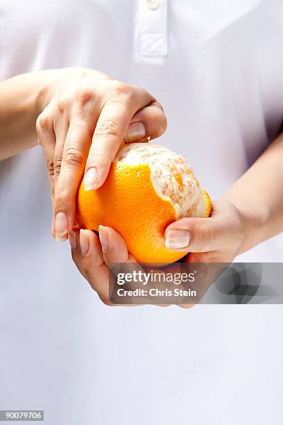 woman peeling an orange - éplucher photos et images de collection