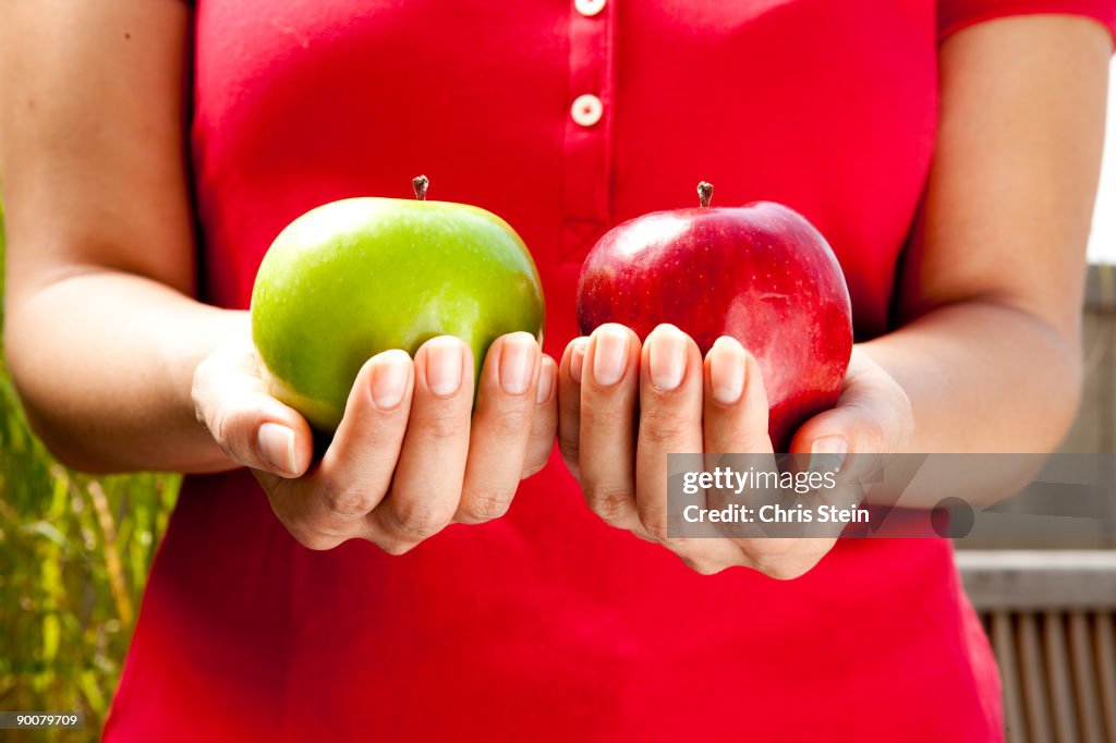 Woman holds two apples