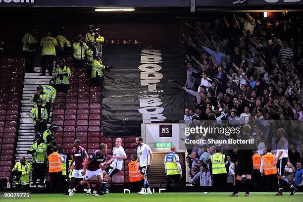 Stewards and Police stand in front of the Millwall fans during the Carling Cup second round match between West Ham United and Millwall at Upton Park...