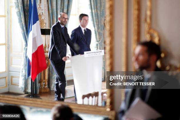 Picture taken on January 3, 2018 shows the reflection in the mirror of French Prime Minister Edouard Philippe delivering a speech next to the...