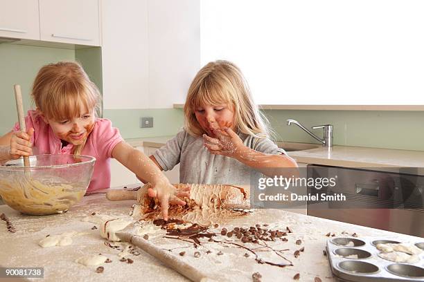 two  young girls cooking - cooking mess imagens e fotografias de stock