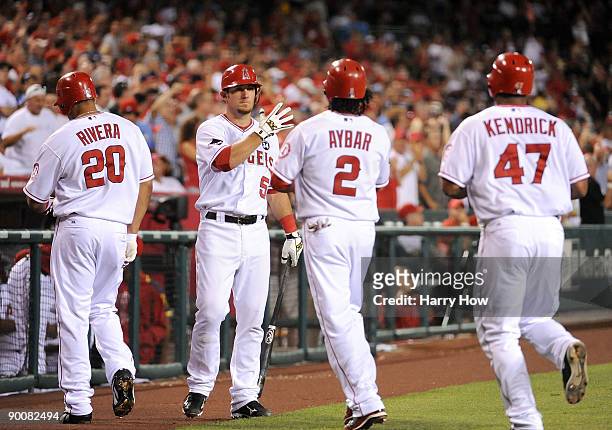 Jeff Mathis of the Los Angeles Angels of Anaheim celebrates the three run homerun of Howie Kendrick with Erick Aybar and Juan Rivera during the...