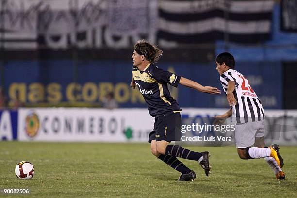 Carlos Espinola of Ecuador's Liga Deportiva Universitaria de Quito vies for the ball with Rodolfo Gamarra of Paraguay's Libertad during their match...