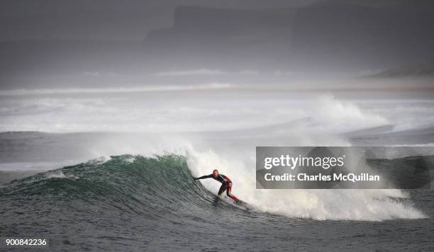 Surfer Al Mennie catches a wave at east strand beach after Storm Eleanor on January 3, 2018 in Portrush, Northern Ireland. The Met Office has said...