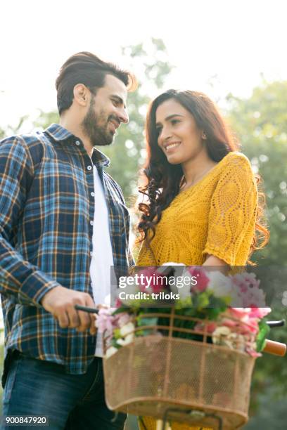 romantic couple with bicycle at park - dating stock pictures, royalty-free photos & images