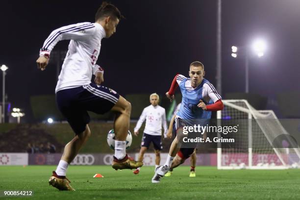 James Rodriguez is challenged by Joshua Kimmich during a training session on day 2 of the FC Bayern Muenchen training camp at ASPIRE Academy for...