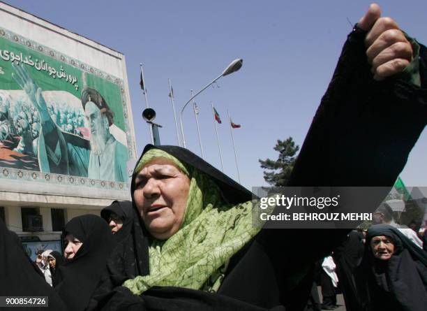 Iranian women chant slogans under a portrait of Iran's late founder of the Islamic Republic Ayatollah Khomeini during a demonstration to protest...