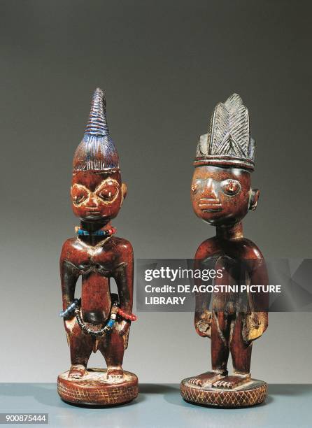 Pair of male and female twins , wood statuettes with applications of beads and amulets, Yoruba population, Africa, 20th century.