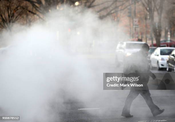 Man walks walks past a steam grate on January 3, 2018 in Washington, DC. A winter storm is traveling up the east coast overnight with significant...