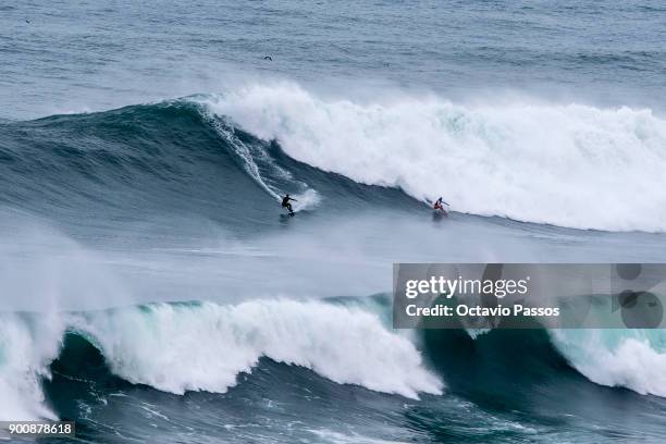 German Sebastian Steudtner and Brazilian Lucas Chumbo big waves surfers drops a wave during a surf session at Praia do Norte on January 3, 2018 in...