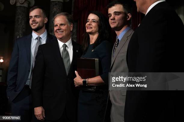 Sen. Doug Jones participates in a group photo with son Carson, wife Louise, and son Christopher after a mock swearing-in ceremony at the Old Senate...