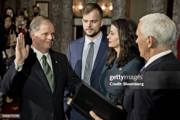 Senator Doug Jones, a Democrat from Alabama, left, is sworn-in by U.S. Vice President Mike Pence, right, during a mock swear-in ceremony with wife...