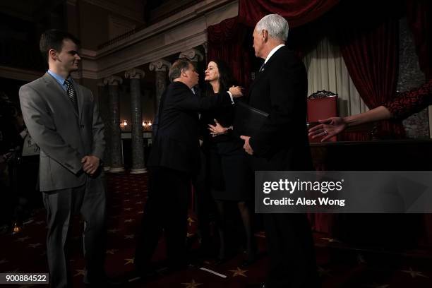 Sen. Doug Jones kisses his wife Louise as son Christopher and Vice President Mike Pence look on during a mock swearing-in ceremony at the Old Senate...
