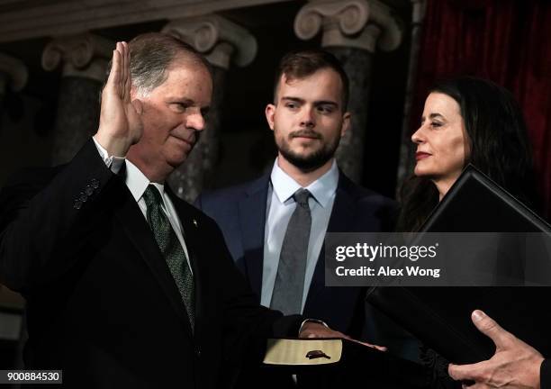 Sen. Doug Jones participates in a mock swearing-in ceremony as Jones' wife Louise and son Carson look on at the Old Senate Chamber of the U.S....