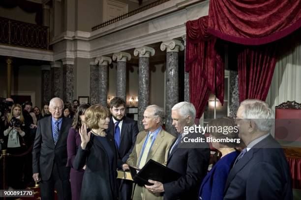Senator Tina Smith, a Democrat from Minnesota, second left, is sworn-in by U.S. Vice President Mike Pence, third right, during a mock swear-in...