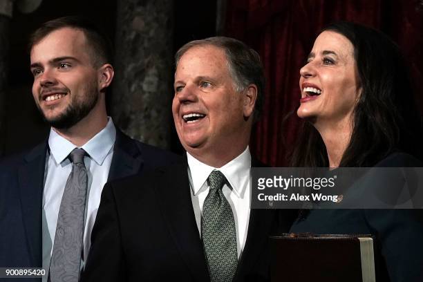 Sen. Doug Jones participates in a group photo with son Carson and wife Louise after a mock swearing-in ceremony at the Old Senate Chamber of the U.S....