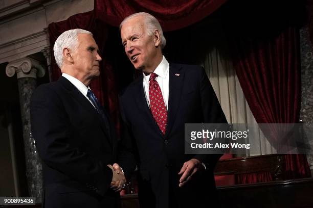Former U.S. Vice President Joseph Biden and incumbent U.S. Vice President Mike Pence share a moment during a mock swearing-in ceremony for U.S. Sen....