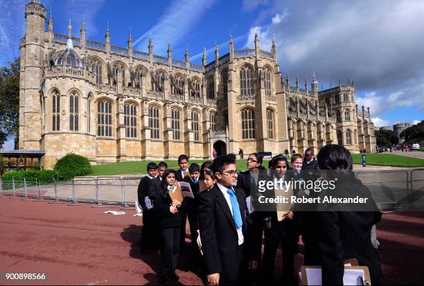 Group of students on a school field trip listen to their teacher in front of St. George's Chapel at Windsor Castle in Windsor, England. Windsor...