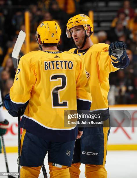 Austin Watson talks with Anthony Bitetto of the Nashville Predators during a stoppage in play against the Minnesota Wild during an NHL game at...