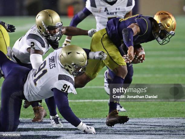 Kevin Stepherson of the Notre Dame Fighting Irish is hit by Tyler Sayles and Jarid Ryan of the Navy Midshipmen at Notre Dame Stadium on November 18,...