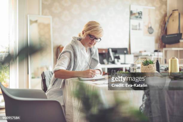 young businesswoman is writing in a personal organizer - calendar 2017 stock pictures, royalty-free photos & images