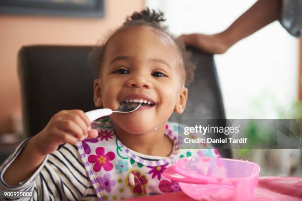 young girl eating - baby bib stock pictures, royalty-free photos & images