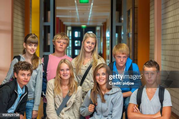 foto de grupo: três quarto tiro comprimento de oito adolescentes meninos e meninas com sacos de ombro no corredor da escola olhando para a câmera, focar as meninas na frente - class photo - fotografias e filmes do acervo