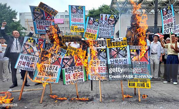 South Korean conservative activists burn placards showing pictures of North Korean leader Kim Jong-Il during an anti-North Korea rally in Seoul on...