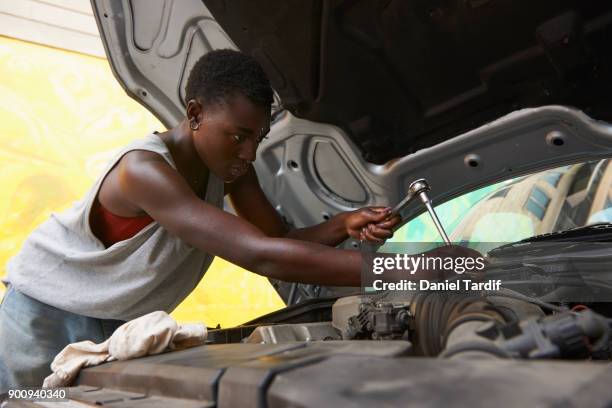 gender fluid woman repairing car - woman leaning stock pictures, royalty-free photos & images
