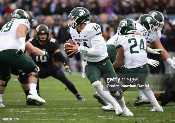 Brian Lewerke of the Michigan State Spartans rolls out to look for a receiver against the Northwestern Wildcats at Ryan Field on October 28, 2017 in...