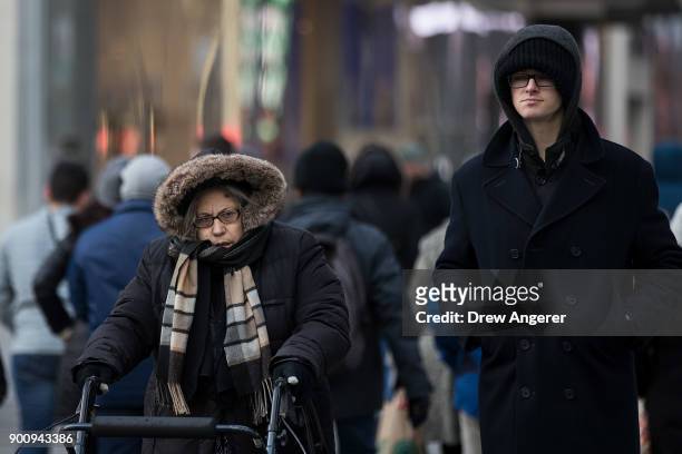 Bundled up pedestrians walk through Midtown Manhattan in below freezing temperatures, January 3, 2018 in New York City. New York City was placed...