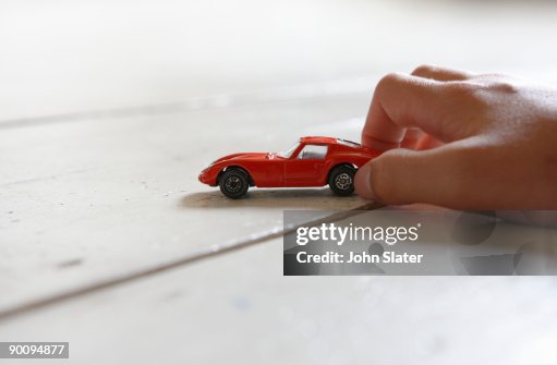 Boy's hand playing with toy car on the floor,low a Boy's hand playing with toy car on the floor,low a