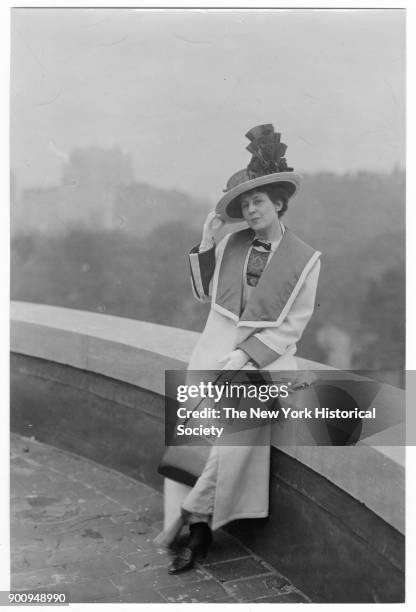 Actress Viola Allen in long coat and hat, with purse, on a roof overlooking Central Park, 1925.