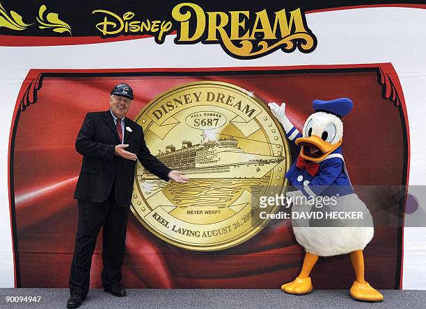 Donal Duck and Karl Holz, president of the Disney Cruise Line, pose during the keel laying of the cruiser "Disney Dream" next to a fortune coin on...