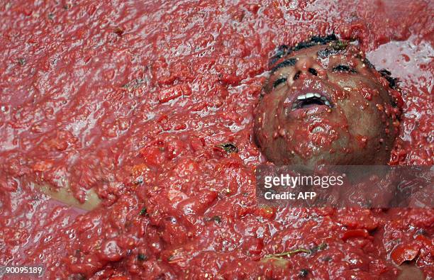 Man bathes in tomatoes during the "Tomatina" food festival on August 26, 2009 in Bunol, Valencia, in the southeastern region of Spain. The festival...